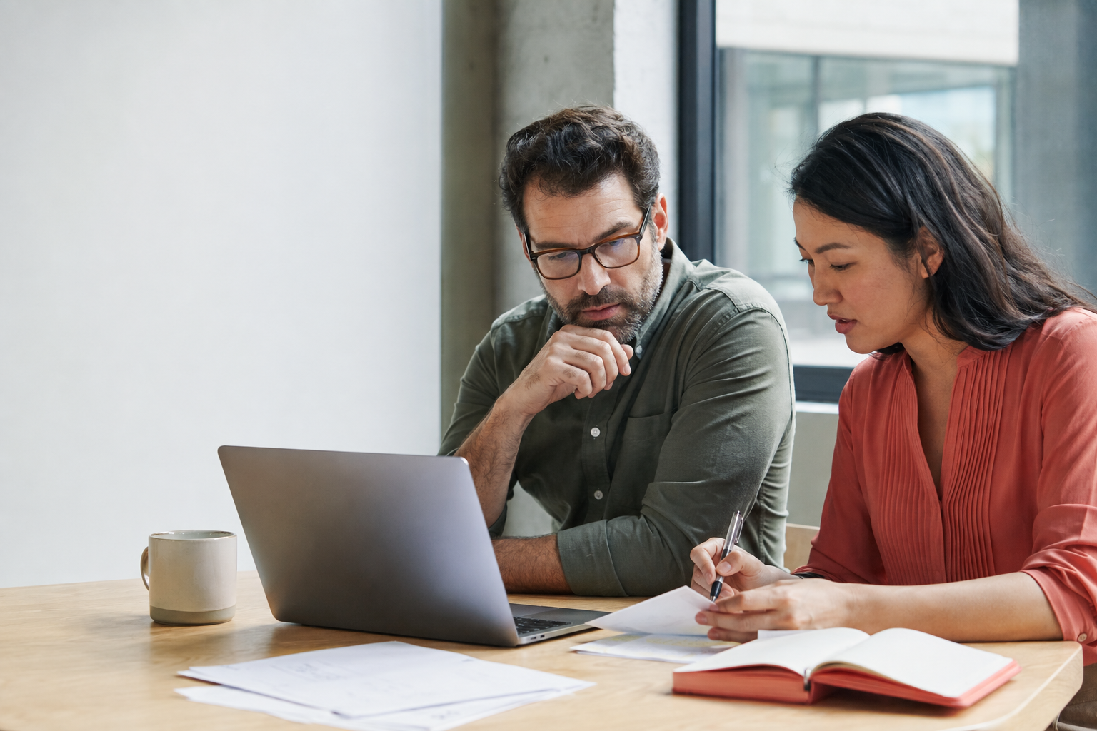 Two teammates reviewing a Gmail outreach draft on a laptop