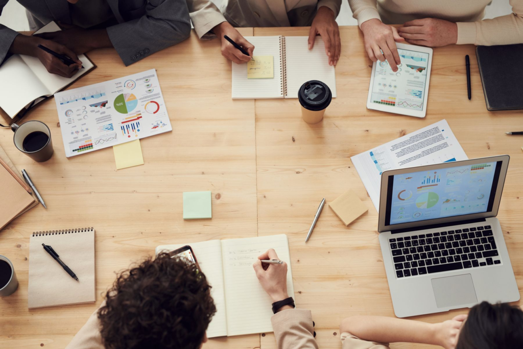 B2B professionals reviewing charts and plans around a meeting table