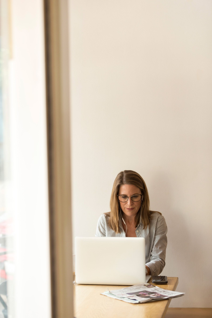 A businesswoman working on a laptop in a bright workspace